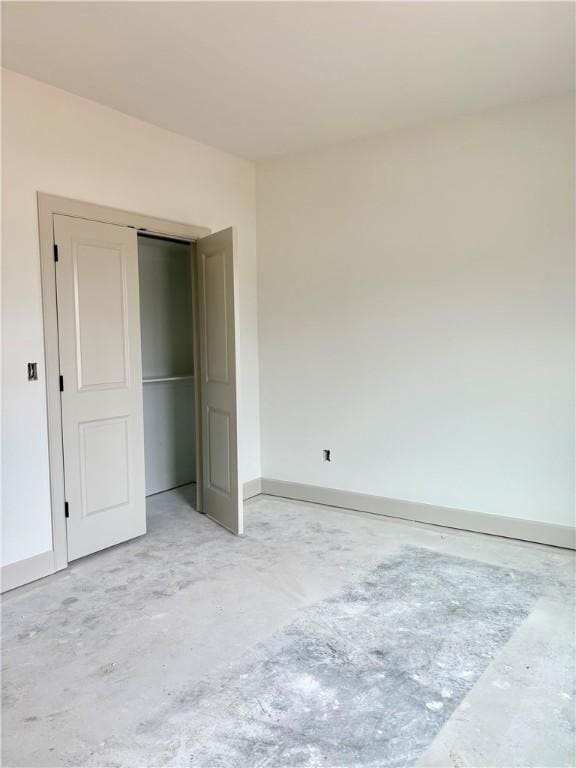 841 Bellagiola Ave, Tontitown, AR 72762 - unfurnished bedroom featuring concrete flooring, baseboards, and a closet