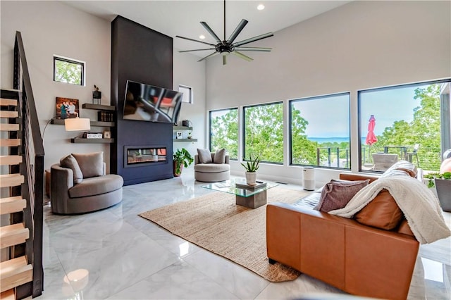675 N Cliffside Dr, Fayetteville, AR 72701 - living area with light marble finish flooring, a ceiling fan, a large fireplace, plenty of natural light, and a high ceiling