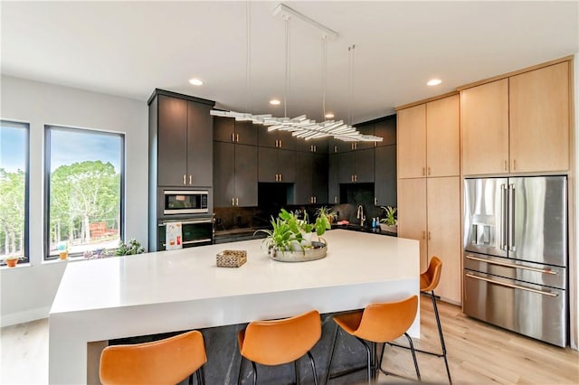 675 N Cliffside Dr, Fayetteville, AR 72701 - kitchen featuring stainless steel appliances, light wood-style flooring, a breakfast bar area, backsplash, and recessed lighting