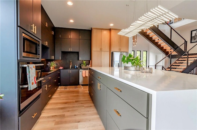 675 N Cliffside Dr, Fayetteville, AR 72701 - kitchen with stainless steel appliances, recessed lighting, decorative backsplash, light wood finished floors, and a spacious island