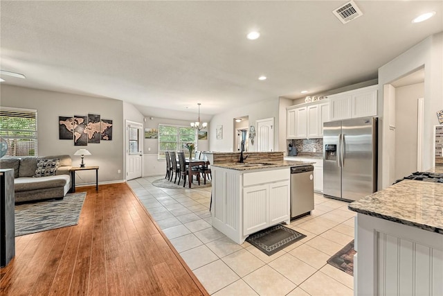 811 SW Pure Globe St, Bentonville, AR 72712 - kitchen featuring appliances with stainless steel finishes, a sink, open floor plan, white cabinetry, and recessed lighting