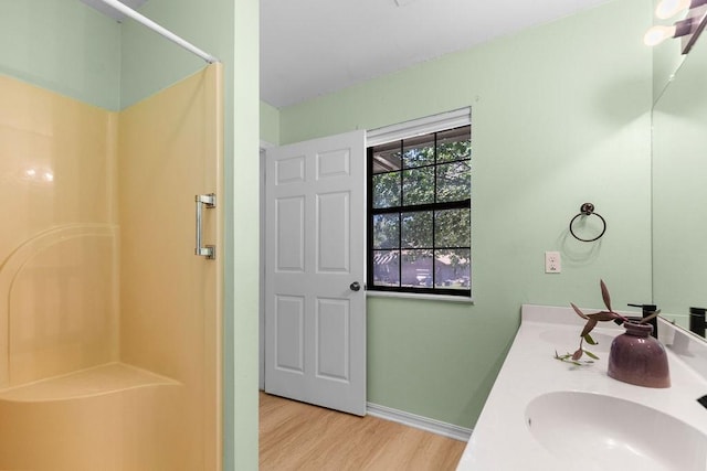 1110 Meadowlark Ln, Siloam Springs, AR 72761 - bathroom featuring a shower, wood finished floors, double vanity, and baseboards