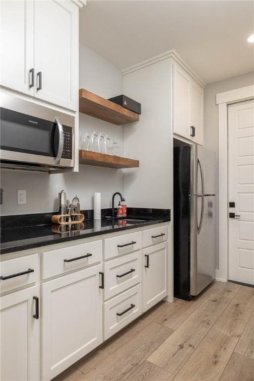 2762 Wilson Ln, Fayetteville, AR 72703 - kitchen featuring stainless steel appliances, a sink, light wood-style flooring, white cabinets, and dark countertops