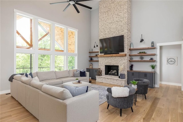 2762 Wilson Ln, Fayetteville, AR 72703 - living room with a towering ceiling, a ceiling fan, a fireplace, light wood-type flooring, and baseboards