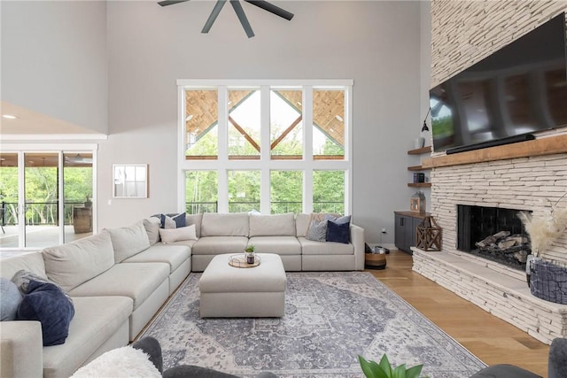 2762 Wilson Ln, Fayetteville, AR 72703 - living room with a towering ceiling, a ceiling fan, healthy amount of natural light, a fireplace, and wood finished floors