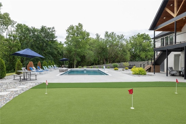 2762 Wilson Ln, Fayetteville, AR 72703 - swimming pool featuring an area to practice putting, a patio area, stairway, and view of wooded area