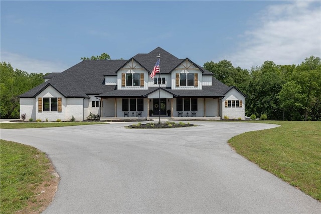 2762 Wilson Ln, Fayetteville, AR 72703 - view of front of house featuring covered porch, curved driveway, a front yard, and roof with shingles