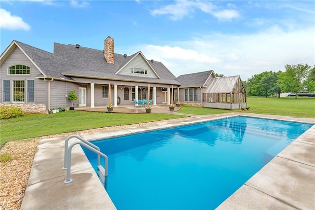 12292 Butler Rd, Prairie Grove, AR 72753 - back of house with an outdoor pool, a chimney, a patio area, and a lawn