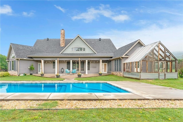 12292 Butler Rd, Prairie Grove, AR 72753 - rear view of property featuring a patio area, a sunroom, a chimney, an outdoor pool, and roof with shingles
