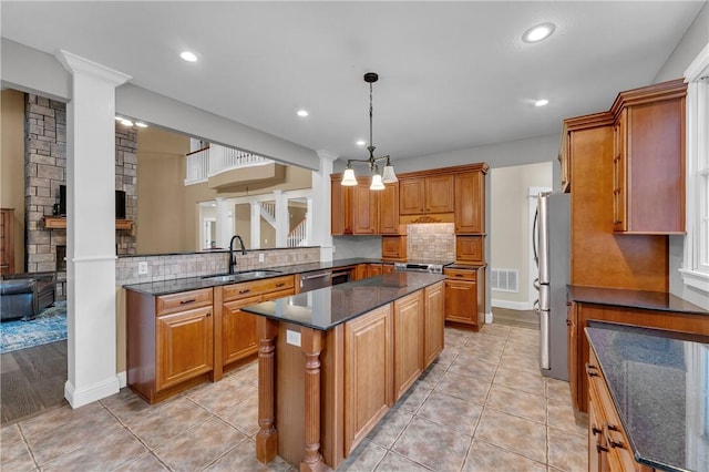 12292 Butler Rd, Prairie Grove, AR 72753 - kitchen featuring a sink, appliances with stainless steel finishes, a center island, brown cabinets, and dark stone counters