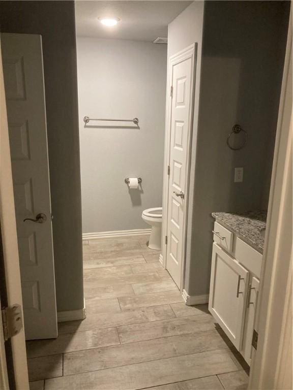 1211/1213 N Sicily Ln, Fayetteville, AR 72704 - bathroom with vanity, wood finished floors, toilet, and baseboards