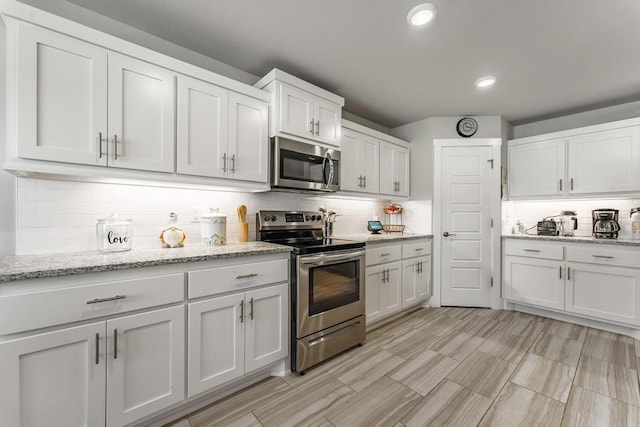 6 Briscoe Ln, Bella Vista, AR 72715 - kitchen featuring appliances with stainless steel finishes, tasteful backsplash, white cabinetry, recessed lighting, and light stone countertops