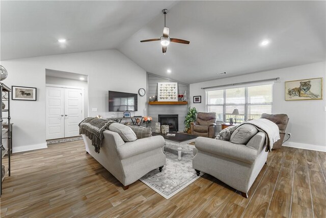 6 Briscoe Ln, Bella Vista, AR 72715 - living room with a ceiling fan, lofted ceiling, wood finished floors, a brick fireplace, and baseboards