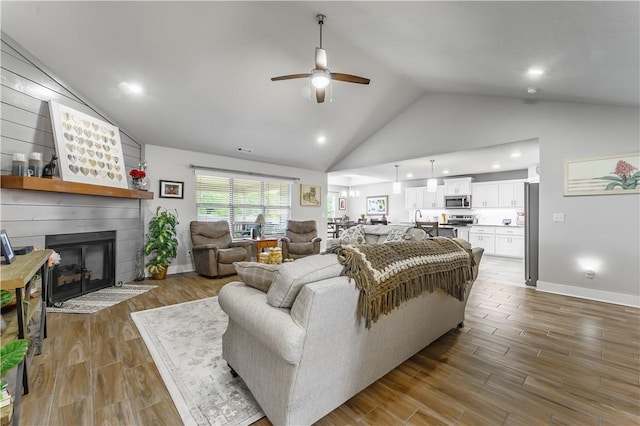 6 Briscoe Ln, Bella Vista, AR 72715 - living room featuring a ceiling fan, wood finished floors, high vaulted ceiling, a large fireplace, and recessed lighting