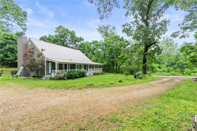 14090 Canal St, Rogers, AR 72758 - view of side of property featuring covered porch, a chimney, a yard, and metal roof