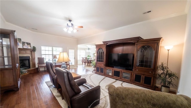 1011 Harvest St, Centerton, AR 72719 - living room with ceiling fan, dark wood finished floors, a fireplace with raised hearth, and crown molding