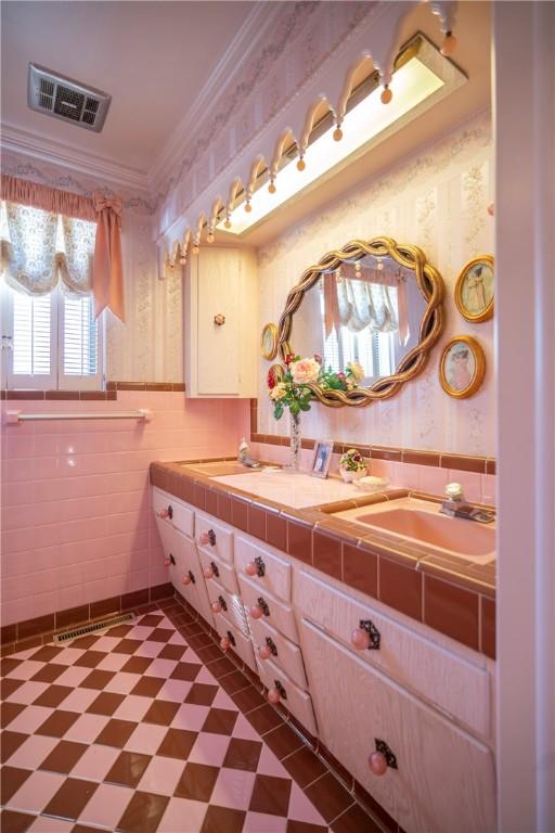 1617 Ranch Dr, Springdale, AR 72762 - full bath with wallpapered walls, tile patterned floors, double vanity, ornamental molding, and tile walls