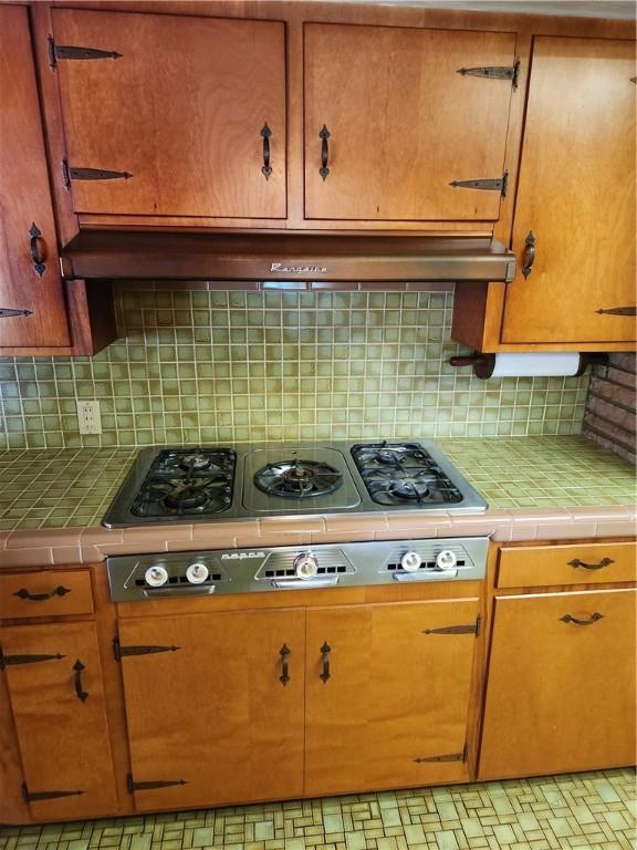 1617 Ranch Dr, Springdale, AR 72762 - kitchen featuring tile counters, tasteful backsplash, gas stovetop, and under cabinet range hood