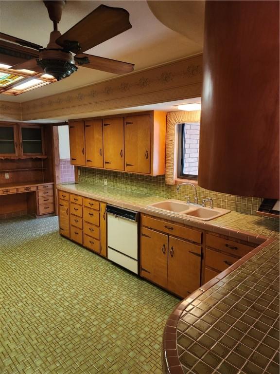 1617 Ranch Dr, Springdale, AR 72762 - kitchen featuring white dishwasher, tile counters, a sink, and decorative backsplash
