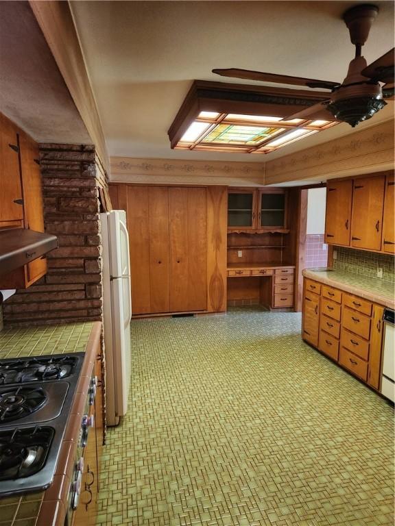 1617 Ranch Dr, Springdale, AR 72762 - kitchen with freestanding refrigerator, tile countertops, tasteful backsplash, and ceiling fan