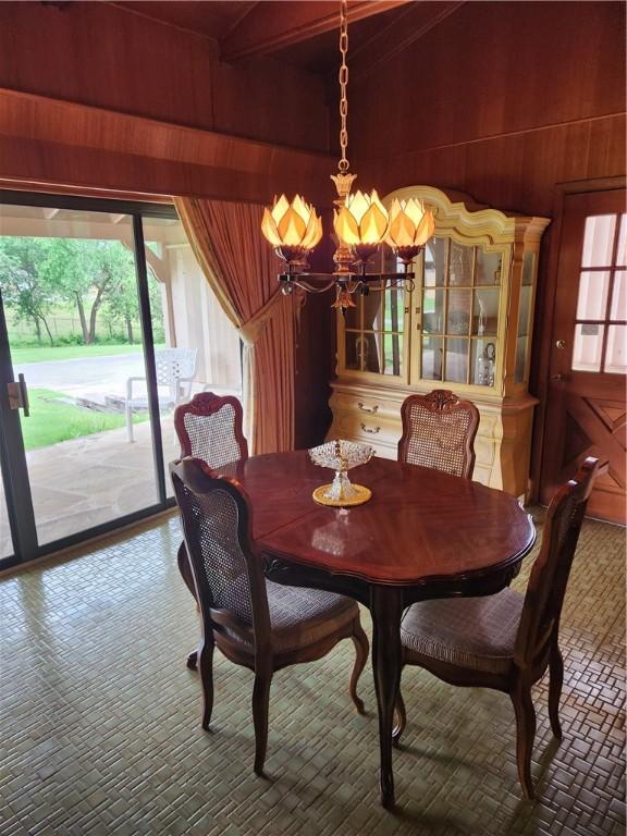1617 Ranch Dr, Springdale, AR 72762 - dining space with a chandelier, wood walls, and beam ceiling