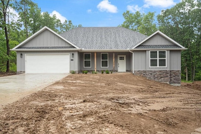 7 Mcginnis Ln, Bella Vista, AR 72715 - view of front of house featuring stone siding, a garage, driveway, a shingled roof, and covered porch