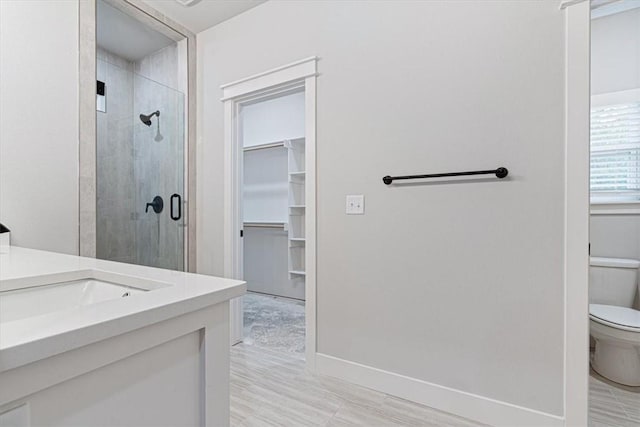 7 Mcginnis Ln, Bella Vista, AR 72715 - bathroom featuring toilet, vanity, a shower stall, a spacious closet, and baseboards