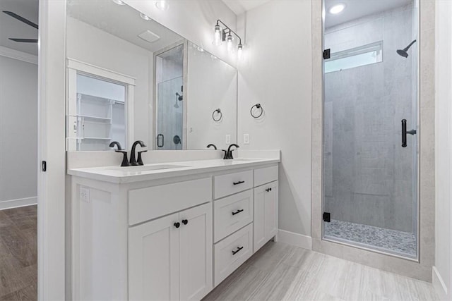 7 Mcginnis Ln, Bella Vista, AR 72715 - bathroom with a shower stall, double vanity, baseboards, a walk in closet, and crown molding