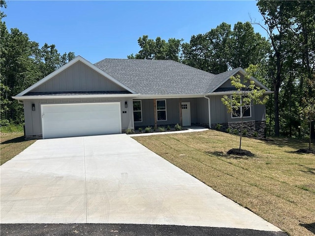 7 Mcginnis Ln, Bella Vista, AR 72715 - view of front facade with a garage, a front lawn, driveway, roof with shingles, and board and batten siding