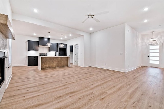 1 Consett Ln, Bella Vista, AR 72714 - unfurnished living room featuring light wood-type flooring, baseboards, recessed lighting, ceiling fan, and a sink