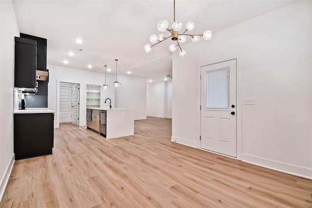1 Consett Ln, Bella Vista, AR 72714 - kitchen featuring light countertops, light wood-type flooring, dark cabinets, a chandelier, and recessed lighting