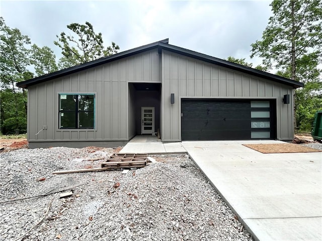 1 Consett Ln, Bella Vista, AR 72714 - modern home featuring board and batten siding, a garage, and driveway