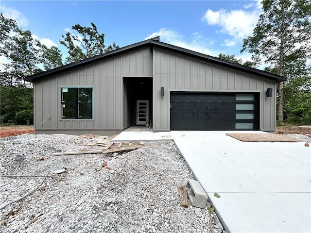 1 Consett Ln, Bella Vista, AR 72714 - view of front of house with concrete driveway, board and batten siding, and an attached garage