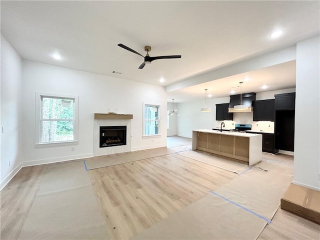 1 Consett Ln, Bella Vista, AR 72714 - unfurnished living room with light wood-type flooring, a ceiling fan, healthy amount of natural light, recessed lighting, and a fireplace