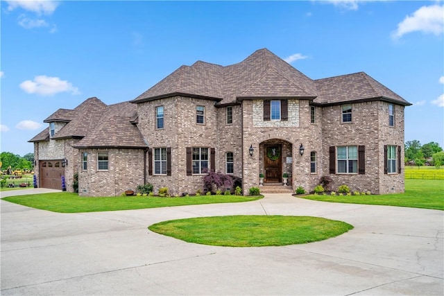 14453 Merritt Dr, Pea Ridge, AR 72751 - french country home with curved driveway, brick siding, a front yard, and a garage