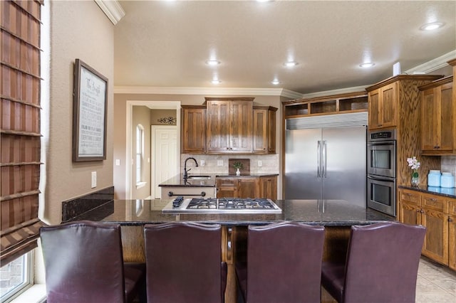 14453 Merritt Dr, Pea Ridge, AR 72751 - kitchen with stainless steel appliances, crown molding, a sink, tasteful backsplash, and brown cabinets