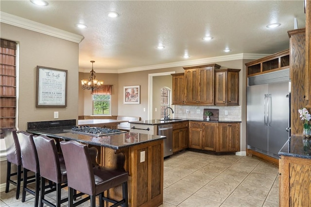 14453 Merritt Dr, Pea Ridge, AR 72751 - kitchen featuring appliances with stainless steel finishes, a peninsula, decorative backsplash, ornamental molding, and a chandelier