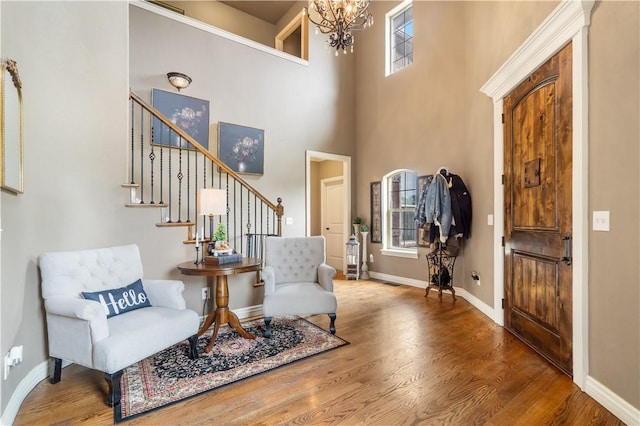 14453 Merritt Dr, Pea Ridge, AR 72751 - entryway with a chandelier, stairway, wood finished floors, a towering ceiling, and baseboards
