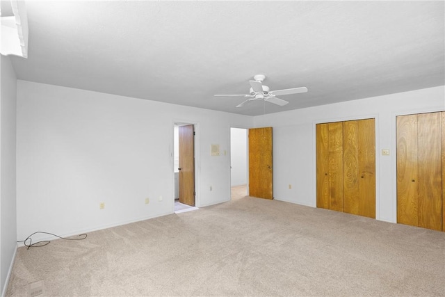 711 W 18th Ter, Russellville, AR 72801 - unfurnished bedroom featuring carpet floors, multiple closets, and a ceiling fan
