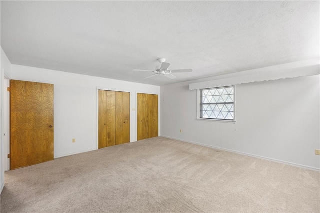 711 W 18th Ter, Russellville, AR 72801 - unfurnished bedroom with two closets, carpet, and ceiling fan