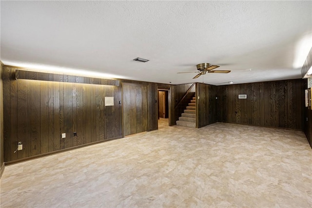 711 W 18th Ter, Russellville, AR 72801 - unfurnished living room with wooden walls, stairs, and ceiling fan