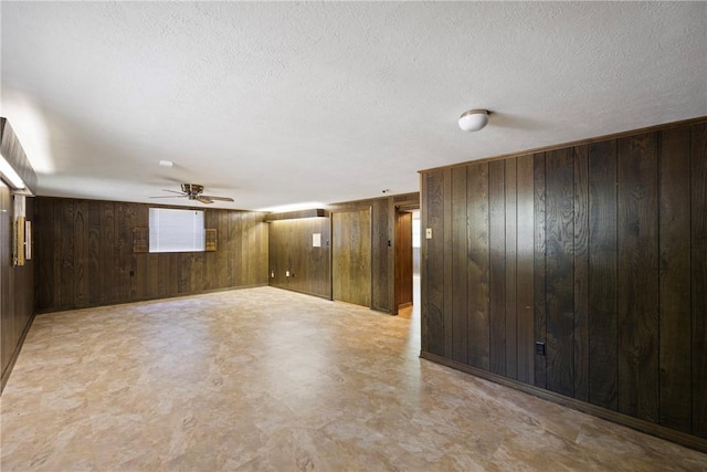 711 W 18th Ter, Russellville, AR 72801 - empty room with wooden walls, a ceiling fan, a textured ceiling, and light flooring