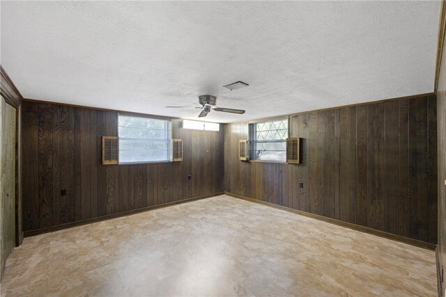 711 W 18th Ter, Russellville, AR 72801 - unfurnished room featuring wood walls, a textured ceiling, and a ceiling fan