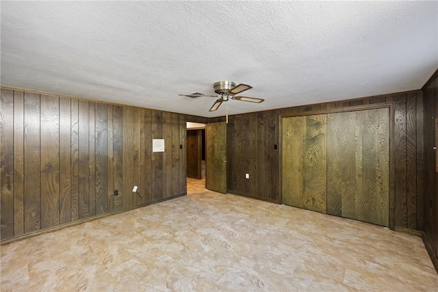 711 W 18th Ter, Russellville, AR 72801 - spare room with a ceiling fan, wooden walls, and a textured ceiling