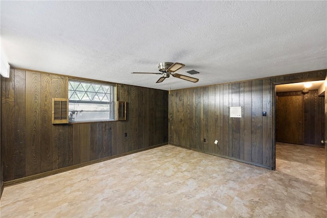 711 W 18th Ter, Russellville, AR 72801 - unfurnished room featuring tile patterned floors, a textured ceiling, wood walls, and a ceiling fan