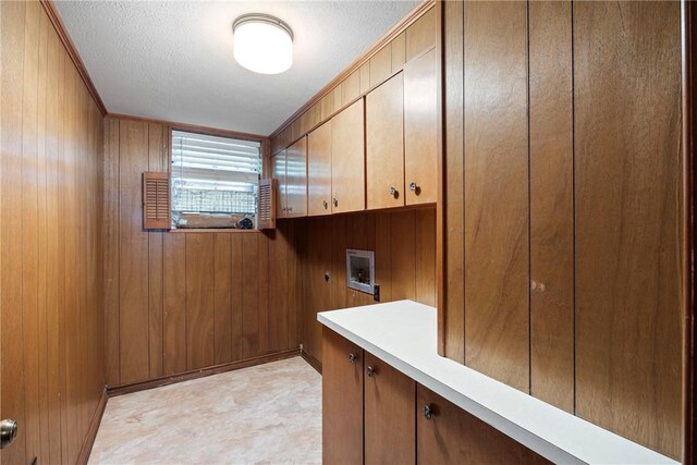 711 W 18th Ter, Russellville, AR 72801 - washroom featuring cabinet space, hookup for a washing machine, wooden walls, hookup for an electric dryer, and a textured ceiling