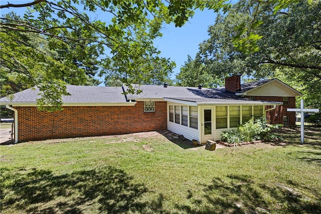 711 W 18th Ter, Russellville, AR 72801 - rear view of house featuring a chimney, a lawn, a sunroom, and roof with shingles
