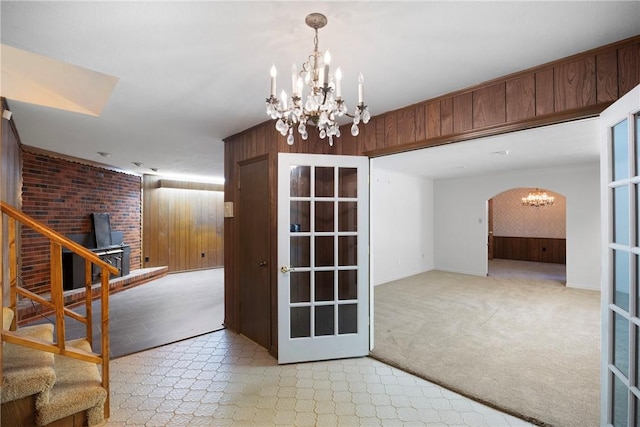 711 W 18th Ter, Russellville, AR 72801 - spare room with a chandelier, wood walls, stairs, arched walkways, and baseboards