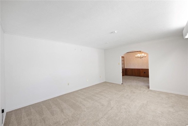 711 W 18th Ter, Russellville, AR 72801 - spare room featuring arched walkways, light colored carpet, a chandelier, and baseboards