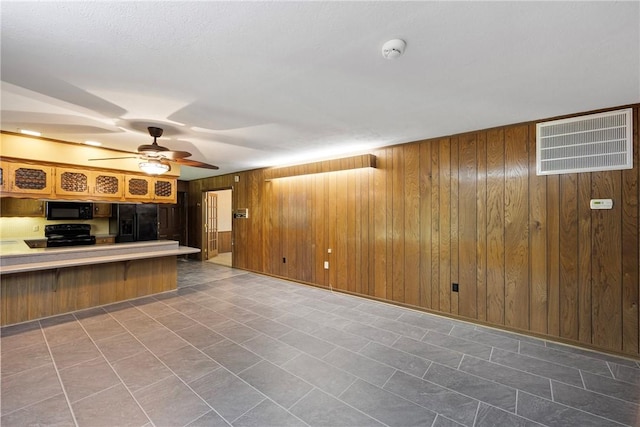 711 W 18th Ter, Russellville, AR 72801 - unfurnished living room featuring wood walls and ceiling fan